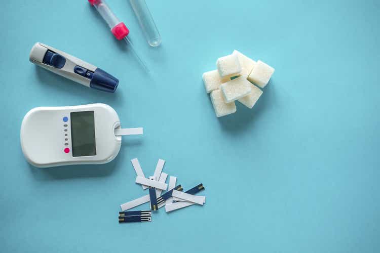 medicine, diabetes diagnostics, healthcare. concept. top view of a blood glucose meter and test strips checking blood sugar levels at home