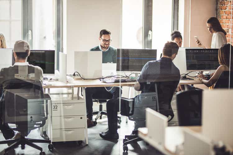 Large group of programmers working on desktop PCs in the office.