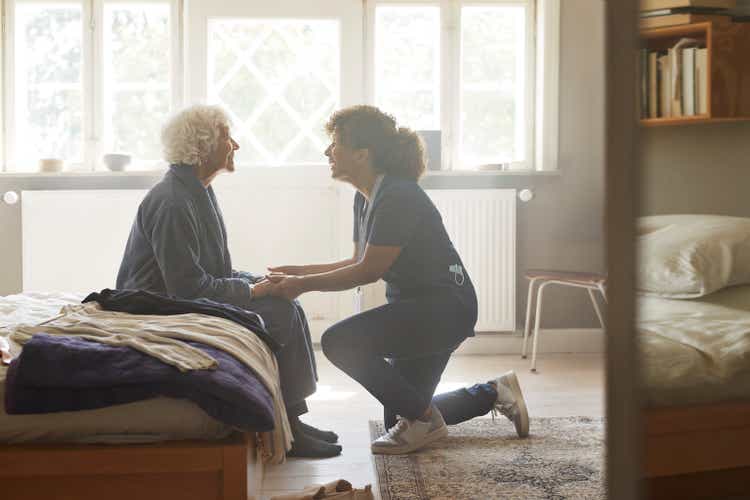 Caregiver holding hands of senior woman