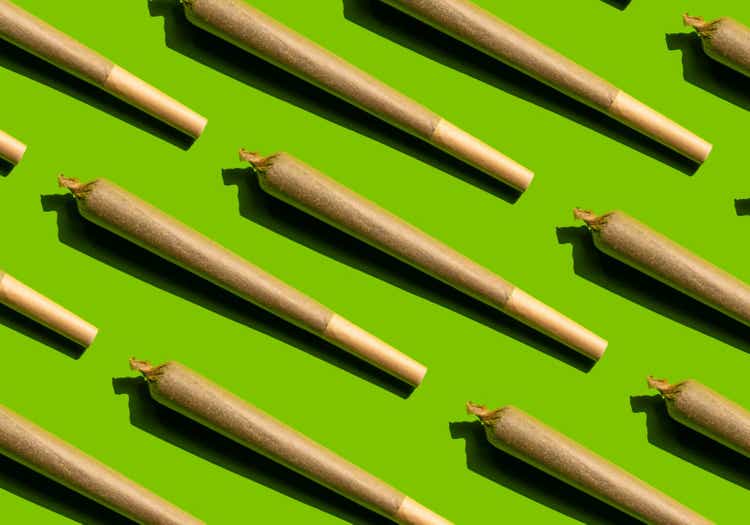Cannabis joint pattern on green background.