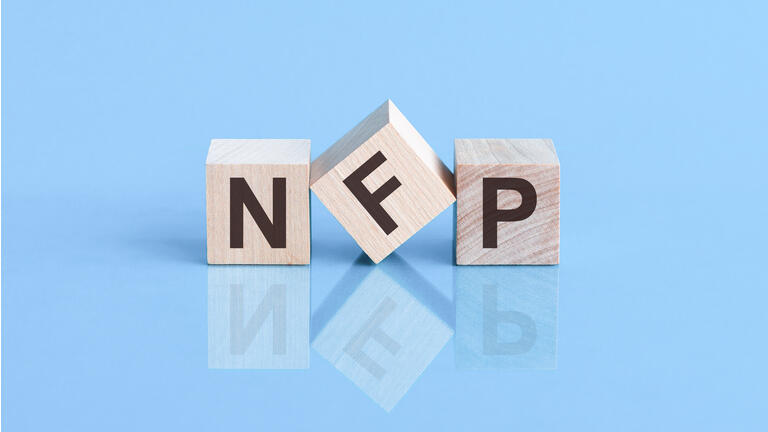 NFP word is made of wooden cubes lying on the blue table, concept