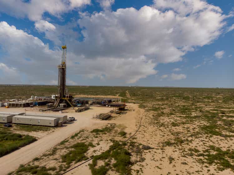 Fracking Drilling Rig Evening Shot under dramatic Sky in West Texas with Settling Ponds on the Prairie