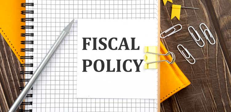 FISCAL POLICY text on a sticker on the notebook, wooden background