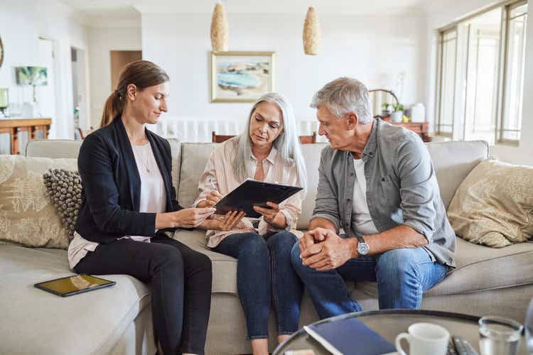 Mature couple with insurance agent at home