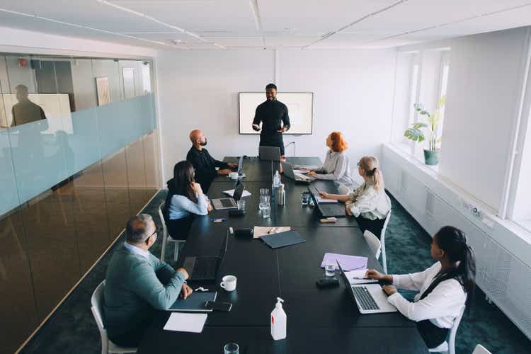 High angle view of businessman giving presentation colleagues in board room at office