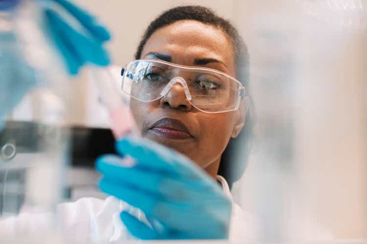 Mature female virologist wearing eyeglasses experimenting in laboratory