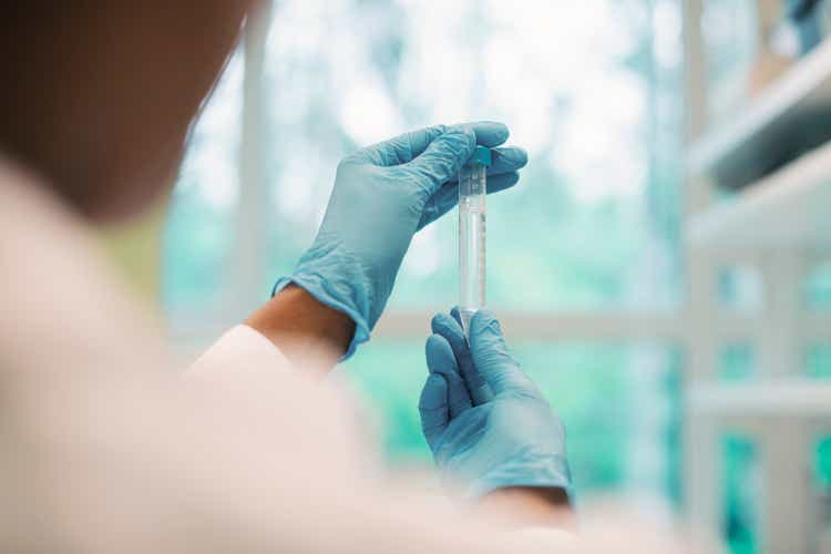 Mature female virologist examining test tubes while working in the laboratory