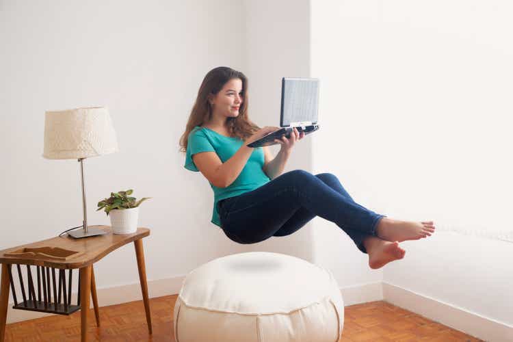 woman floating in air with laptop