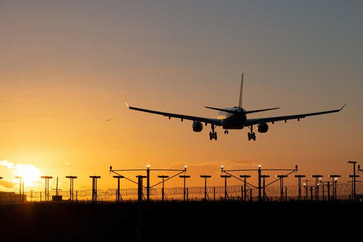 Landing passenger plane during sunset.