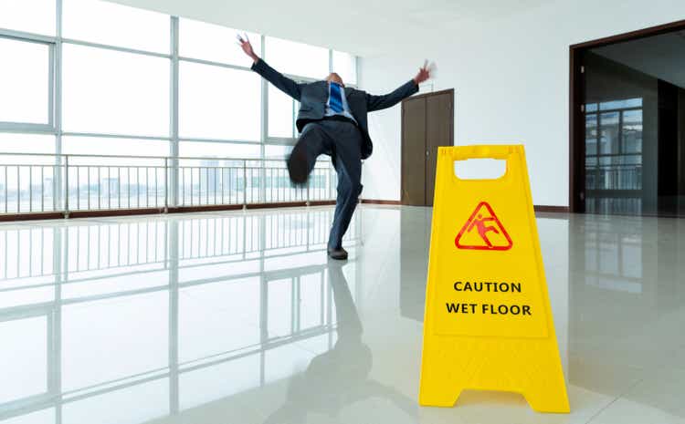 Businessman slipping by the warning sign