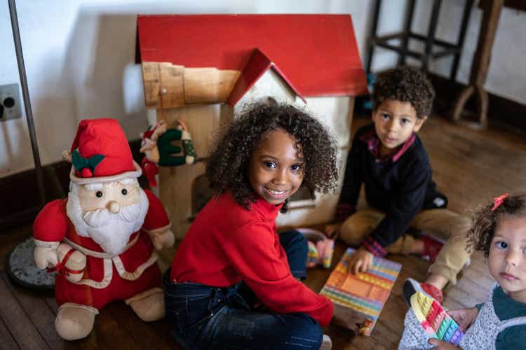 Portrait of a girl playing with siblings at home