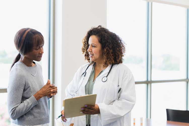 Female doctor and senior patient discuss medical records