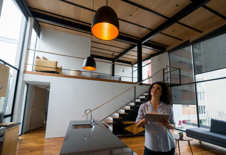 Woman controlling the lights of her house using a home automation system