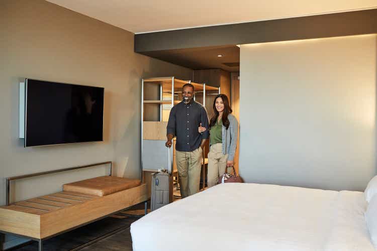 Couple arriving in hotel room during weekend