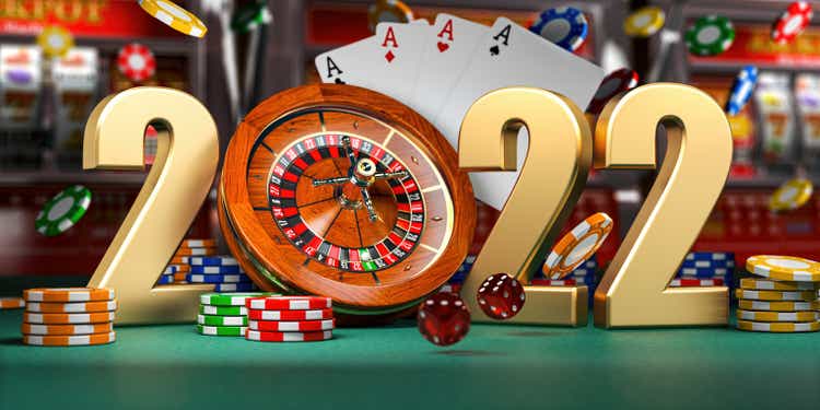 2022 Happy New Year in casino. Numbers 2022 from roulette, casiino chips with dice and card on green table.