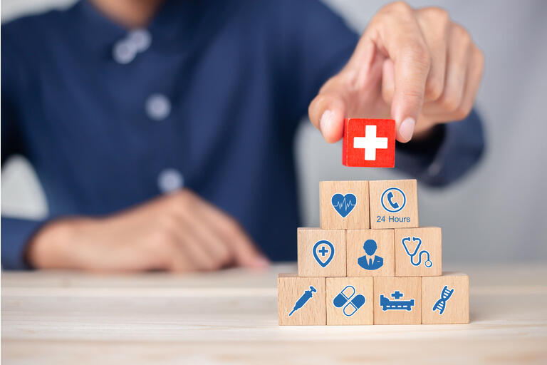 Hand arranging wood block stacking with icon healthcare medical, Health insurance - concept.