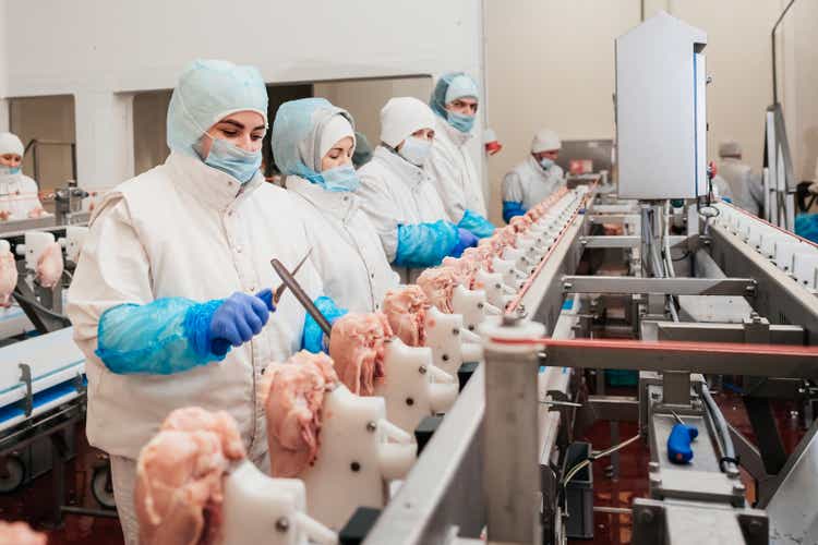Meat processing plant.Industrial equipment at a meat factory.Modern poultry processing plant.People working at a chicken factory - stock photo.Automated production line in modern food factory.
