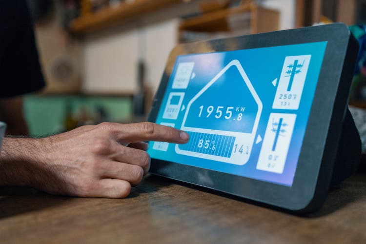 Mid adult man checks electricity consumption for his home with a smart device