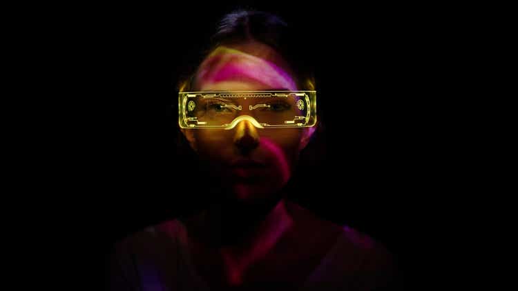 Projection on a woman"s face wearing futuristic glasses