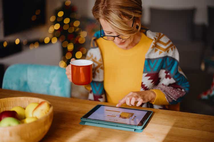 Mature woman using digital tablet for online Christmas shopping