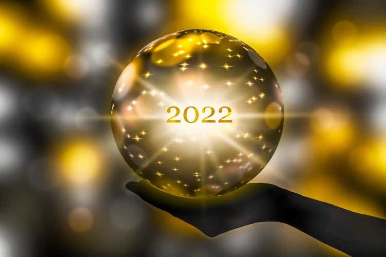 golden crystal ball in a hand, prediction for 2022, brights stars and sparks on abstract shiny background