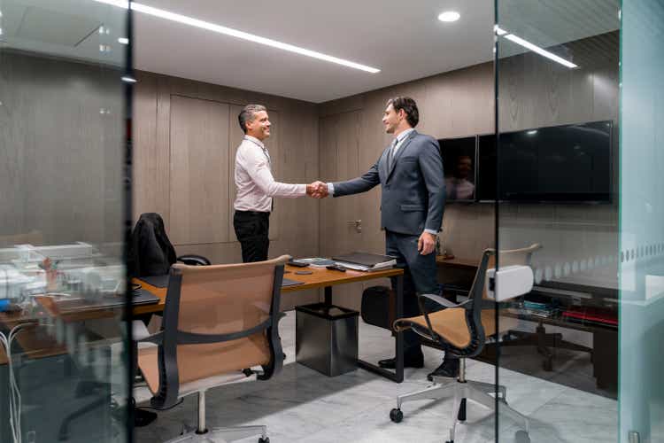 Business men in a meeting closing a deal with a handshake