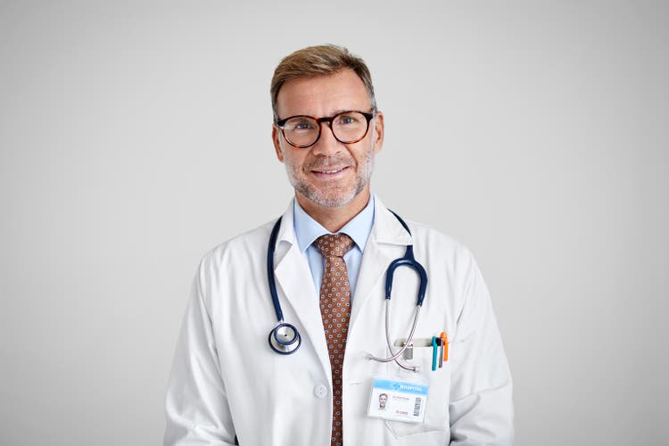 Confident Male Doctor Against White Background