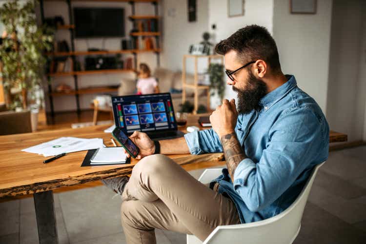 Cryptocurrency investor trading at home using his laptop