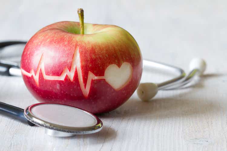 Heartbeat line on red apple and stethoscope, healthy heart diet concept