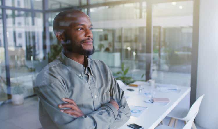 Shot of a confident young businessman looking thoughtfully out of a window in a modern office