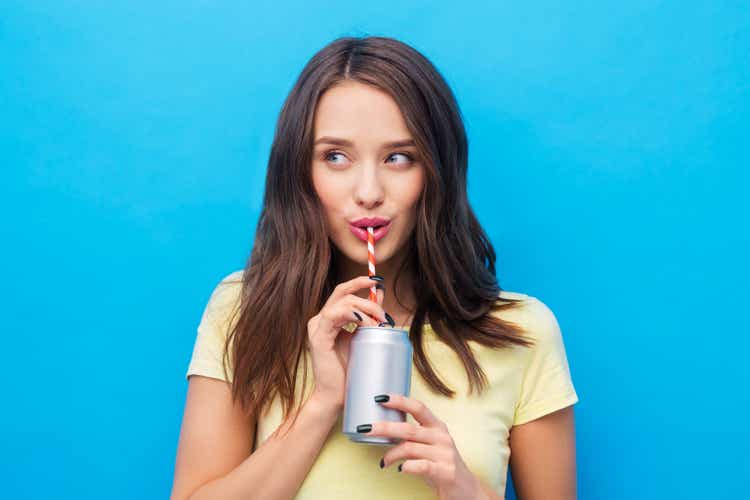 young woman or teenage girl drinking soda from can