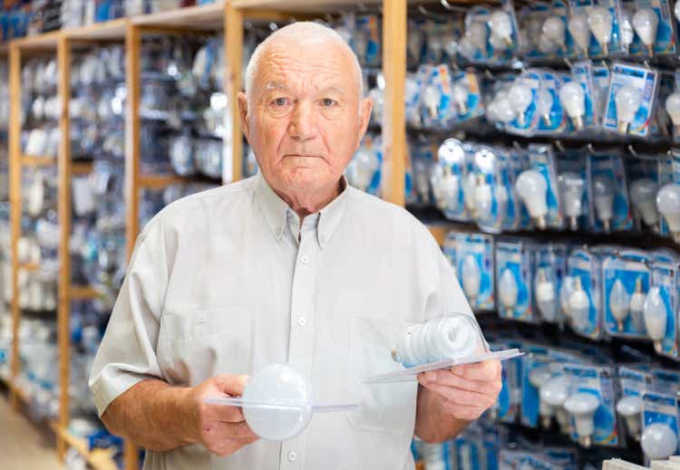 Elderly male buyer selecting light bulbs