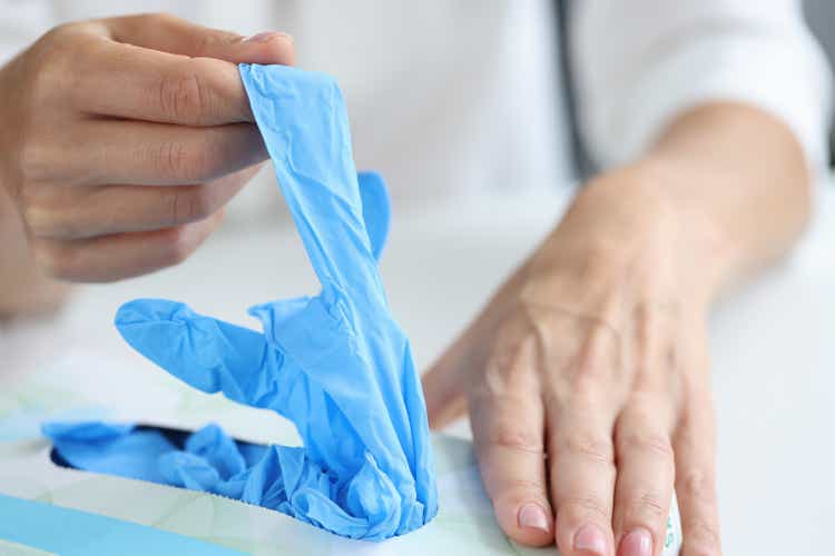 Woman takes out disposable gloves from box closeup