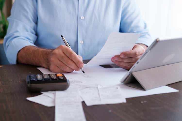 Man calculating personal expenses at home