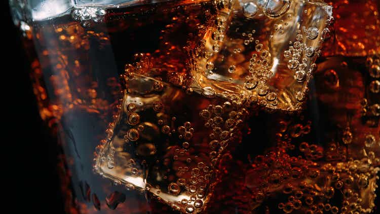 Close-up of a glass of cola with ice cubes and bubbles
