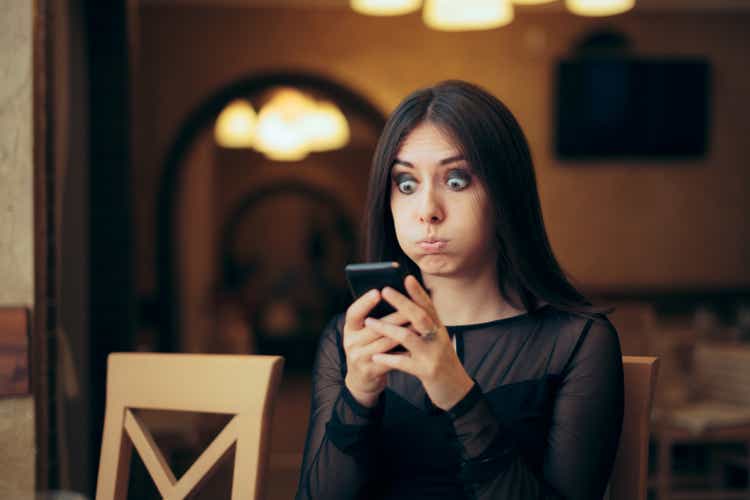 Surprised young woman receives a text message