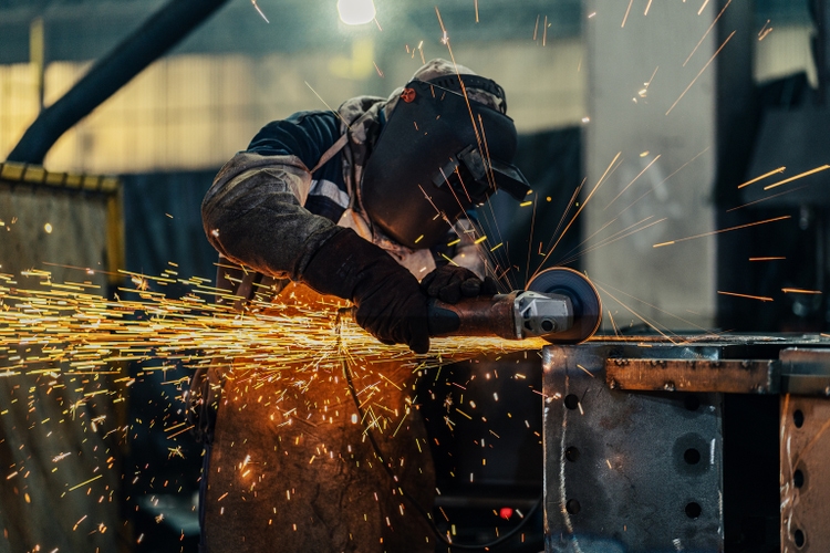 Metal worker using a grinder