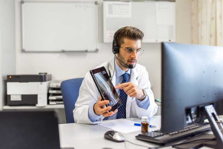Doctor explains patient"s tomography on a telemedicine video call