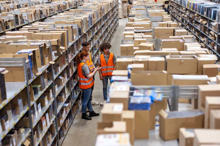 Multiracial warehouse workers discussing inventory in the warehouse.