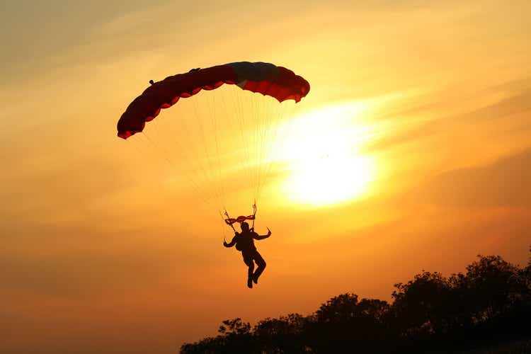 Skydiver landing the parachute at the sunset