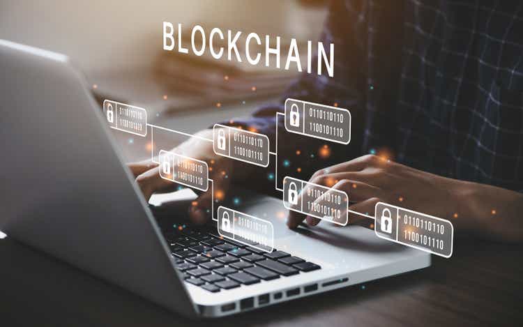 Poslovni čovjek koristi računalo za koncept tehnologije Blockchain s lancem šifriranih blokova za osiguranje kriptovaluta i bitcoina za online plaćanja i novčane transakcije