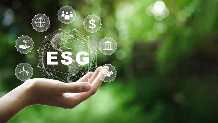 ESG icon concept in the hand for environmental, social, and governance in sustainable and ethical business on the Network connection on a green background.