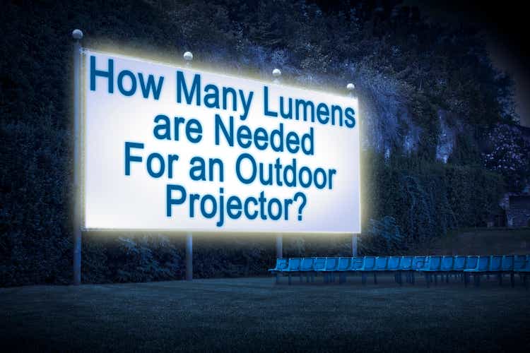 How many lumens are needed for an outdoor projector? Concept with an open air cinema with chairs and white projection screen