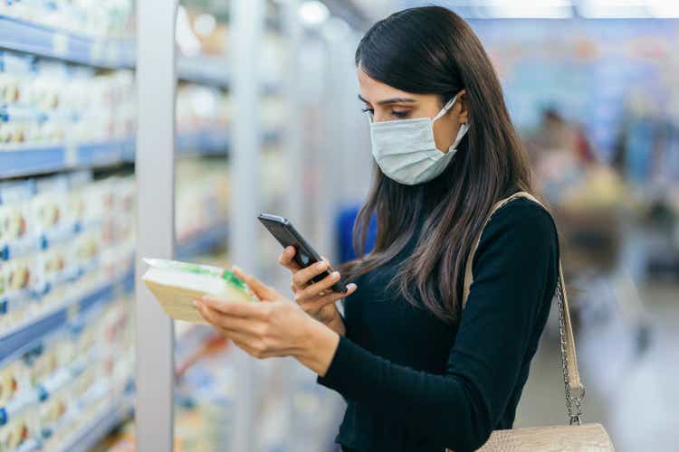 Young woman scanning barcode with smartphone