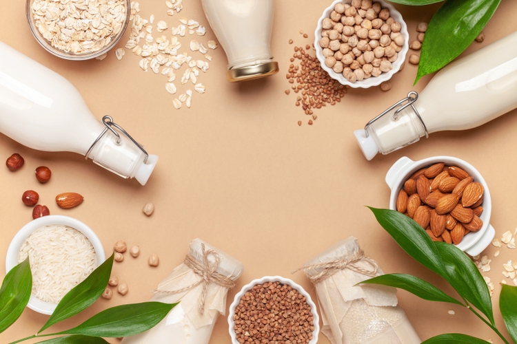 Dairy free alternative plant and nut milk in glass bottles on a gray background. Healthy vegan food concept. Top view