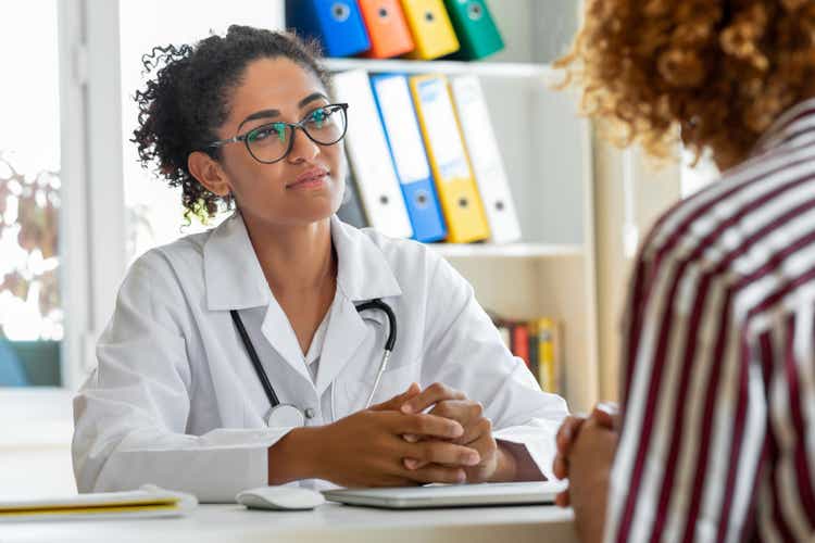 Female patient speaking with her paediatrician in a doctors office