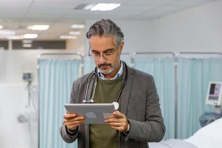 Doctor reviewing patient medical record on digital tablet