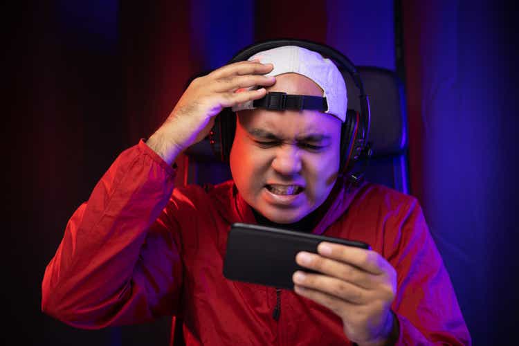 Sadness asian gamer man playing smartphone. He lose in the game. Missed the chance to become a champion in tournament. Unhappy upset Indian streaming video game online and lost.