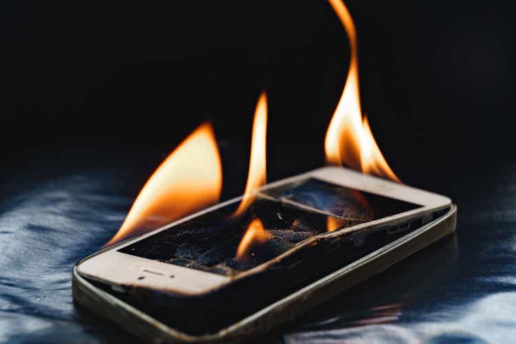 burning broken smartphone on a black background.