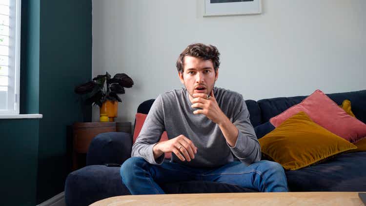 young man looking shocked on sofa